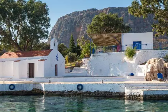 Île de Kastellórizo : panorama avec église et maison au bord mer transparente du Dodécanèse